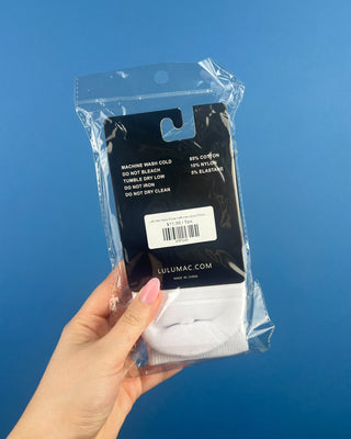 Lulu Mac Half-Crew Seamless Toe Single Pair Socks. In colors Hot Pink, Light blue, Orange, Grey, and Tan. Displayed against a solid blue background. 