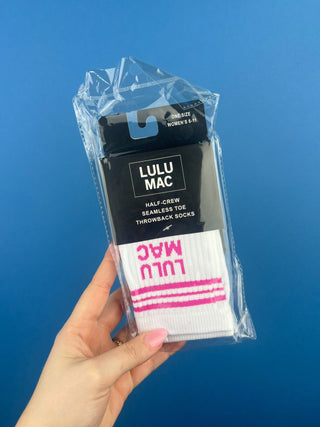 Lulu Mac Half-Crew Seamless Toe Single Pair Socks. In colors Hot Pink, Light blue, Orange, Grey, and Tan. Displayed against a solid blue background. 