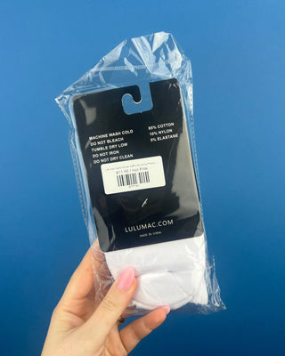 Lulu Mac Half-Crew Seamless Toe Single Pair Socks. In colors Hot Pink, Light blue, Orange, Grey, and Tan. Displayed against a solid blue background. 