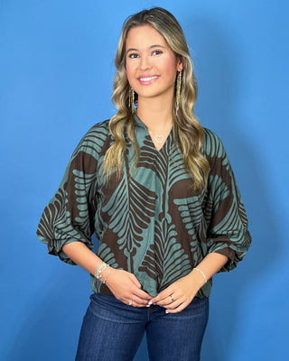 Sage green and brown leaf print blouse with a V-neckline, relaxed fit, and three-quarter balloon sleeves.