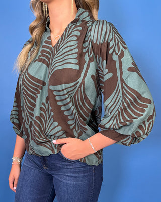 Sage green and brown leaf print blouse with a V-neckline, relaxed fit, and three-quarter balloon sleeves.