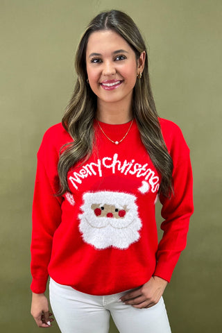 Woman wearing a red Christmas sweater with a Santa Claus design on a beige background