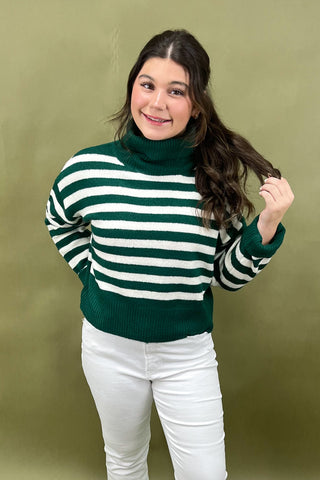 Woman wearing a green and white striped sweater against a green background