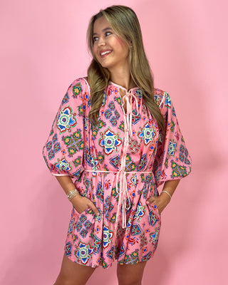 Woman wearing a pink floral dress against a pink background