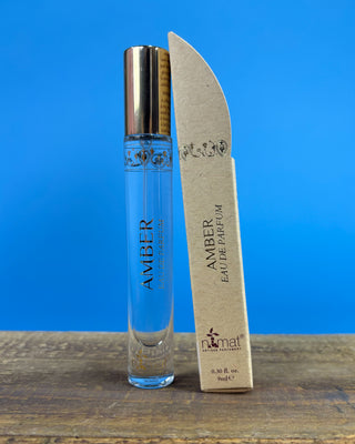 Nemat Amber Eau de Parfum Travel Spray in a 0.30 fl oz (9 mL) travel-size bottle with a fine mist spray applicator, featuring a vegan, cruelty-free, paraben-free fragrance in a sleek portable design.