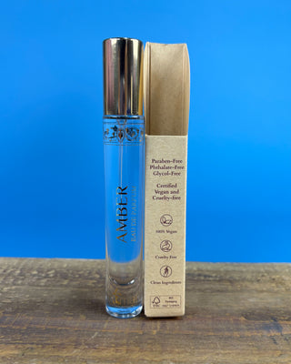 Nemat Amber Eau de Parfum Travel Spray in a 0.30 fl oz (9 mL) travel-size bottle with a fine mist spray applicator, featuring a vegan, cruelty-free, paraben-free fragrance in a sleek portable design.