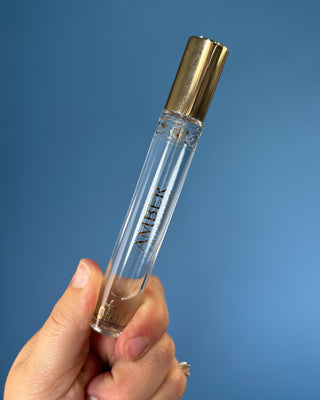 Nemat Amber Eau de Parfum Travel Spray in a 0.30 fl oz (9 mL) travel-size bottle with a fine mist spray applicator, featuring a vegan, cruelty-free, paraben-free fragrance in a sleek portable design.