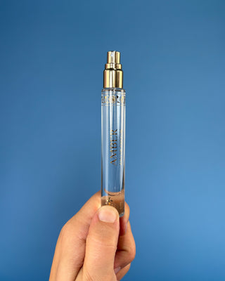 Nemat Amber Eau de Parfum Travel Spray in a 0.30 fl oz (9 mL) travel-size bottle with a fine mist spray applicator, featuring a vegan, cruelty-free, paraben-free fragrance in a sleek portable design.