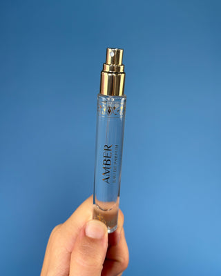 Nemat Amber Eau de Parfum Travel Spray in a 0.30 fl oz (9 mL) travel-size bottle with a fine mist spray applicator, featuring a vegan, cruelty-free, paraben-free fragrance in a sleek portable design.