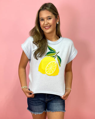Woman wearing a white t-shirt with a lemon graphic on a pink background