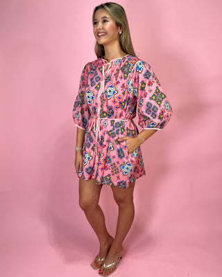 Woman wearing a pink floral dress against a pink background