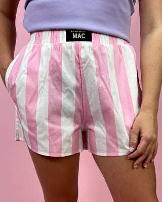 Person wearing pink and white striped shorts with a MAC label on a pink background