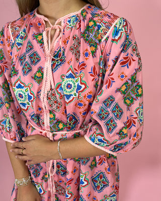 Colorful patterned dress with a pink background