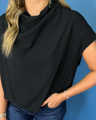 Black short sleeve top with a draped cowl neckline and relaxed silhouette.