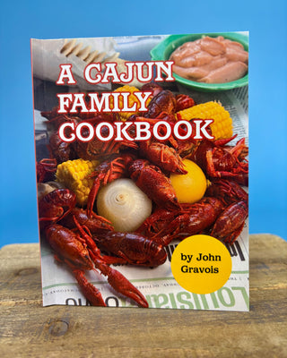 A Cajun Family Cookbook paperback by John Gravois featuring authentic Louisiana Cajun recipes for appetizers, seafood, gumbo, desserts, and traditional Southern family meals.