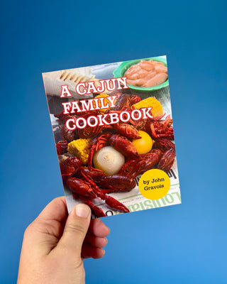 A Cajun Family Cookbook paperback by John Gravois featuring authentic Louisiana Cajun recipes for appetizers, seafood, gumbo, desserts, and traditional Southern family meals.