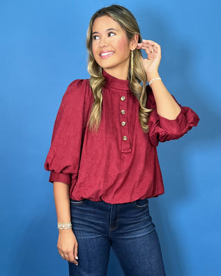Burgundy stand collar blouse with button-front detail, three-quarter puff sleeves, and a relaxed fit.