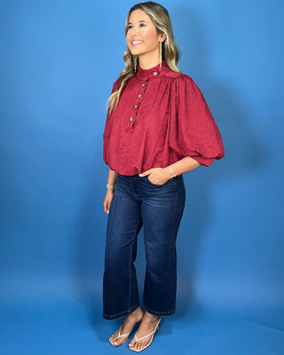 Burgundy stand collar blouse with button-front detail, three-quarter puff sleeves, and a relaxed fit.