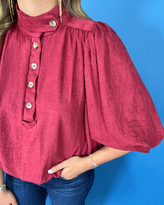Burgundy stand collar blouse with button-front detail, three-quarter puff sleeves, and a relaxed fit.