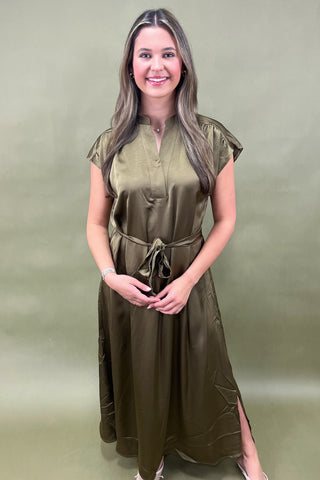 Woman wearing a green dress against a plain background