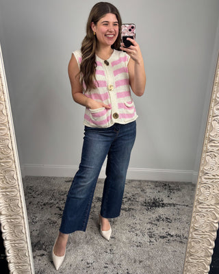 Woman taking a mirror selfie wearing a striped top and jeans in a room with a decorative mirror.