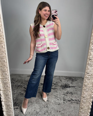 Woman taking a mirror selfie wearing a striped top and jeans.