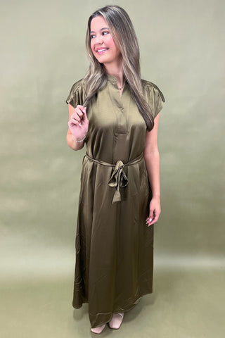 Woman wearing a green dress against a matching background