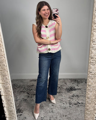 Woman taking a mirror selfie wearing a striped top and jeans.