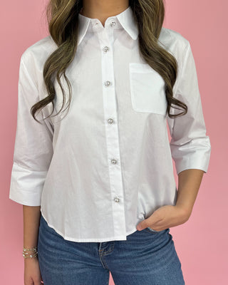 White button-up shirt worn by a person on a pink background
