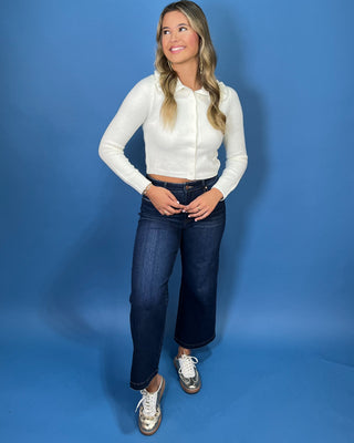 Ivory knit cardigan top with long sleeves, button front and feminine ruffle collar detail.