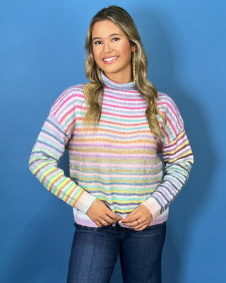 Pastel multicolor striped knit sweater with a cozy mock neckline, long sleeves and relaxed fit.