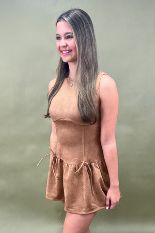 Woman wearing a brown dress against a green background