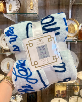 Royal Standard Hail Mary Throw Blanket held up against a store background. 