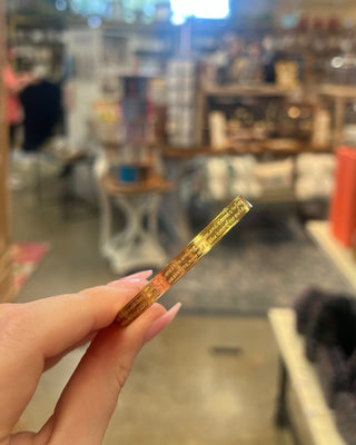 Weisinger Designs Hail Mary Gold Bangle Bracelet. Clasp Open and Close Bracelet, Adult Size displayed in a store background. 