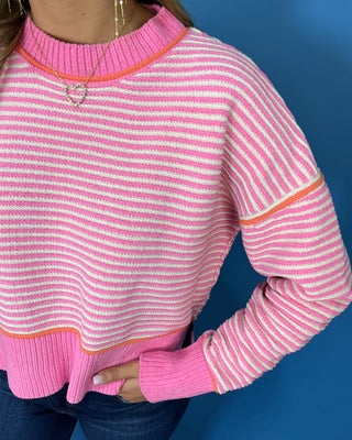 Pink and ivory striped knit sweater with long sleeves, contrast trim and a relaxed fit.