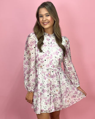 Woman wearing a floral dress against a pink background