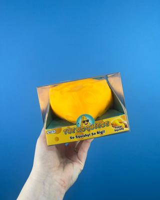 The Big Cheese Triangle Squishy held up against a solid blue background.  