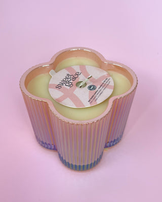 Decorative candle with a 'sweet grace' label on a pink background