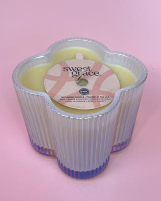 Decorative candle with 'sweet grace' label on a pink background