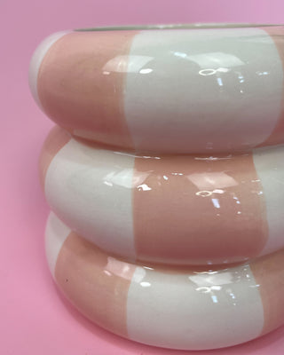 Pink and white striped object on a pink background