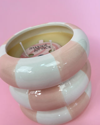 Pink and white striped object with 'sweet grace' branding on a pink background