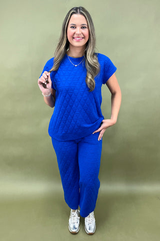 Woman wearing a blue outfit against a green background