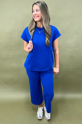 Woman wearing a blue outfit against a green background