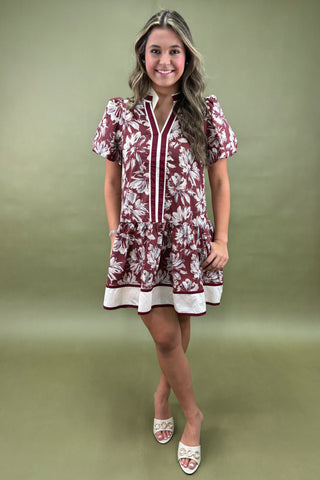 Woman wearing a floral dress against a green background