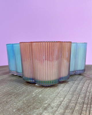 Set of three cylindrical glass candle holders with a gradient design on a wooden surface.