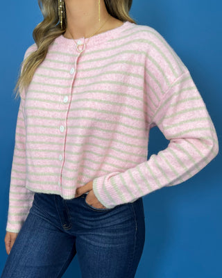 Pink and ivory striped knit cardigan with a round neckline, long sleeves, relaxed fit, and white button-front closure.