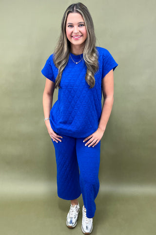 Woman wearing a blue outfit against a gold background