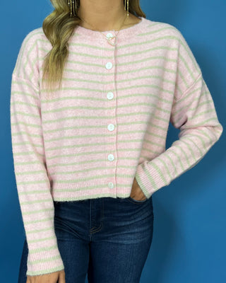 Pink and ivory striped knit cardigan with a round neckline, long sleeves, relaxed fit, and white button-front closure.