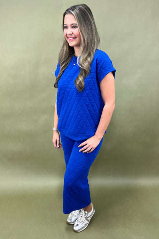 Woman wearing a blue outfit against a green background