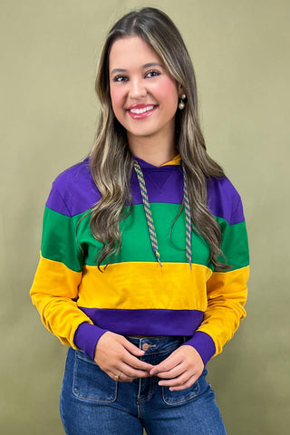 Woman wearing a colorful striped sweater against a beige background
